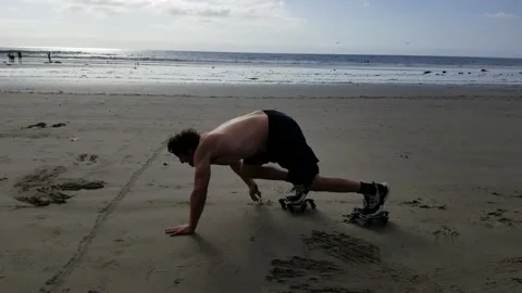 Fit Caucasian Man Performs Bear Crawl Exercise on Beach with Rollers Stock Footage 146552837