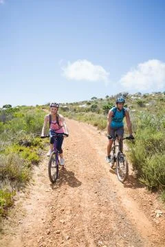 Fit couple cycling up mountain trail Stock Photos