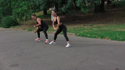Fit couple doing stretch exercises in park. Sport man and woman training legs Stock Footage 141056781
