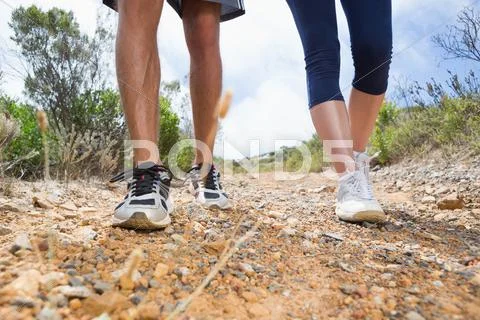 Fit couple walking down mountain trail Stock Photos