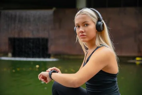 Fit female runner using smart watch to monitor her performance. Stock Photos