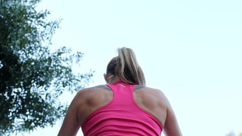 Close-up, a woman in black thongs and sports top, does, performs