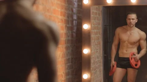 Fit guy doing biceps curls with plate in mirror. Ungraded Stock Footage 63301383