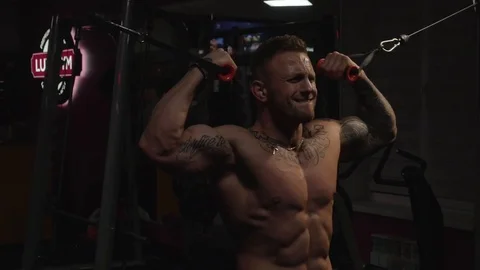 Fit guy doing biceps curls in cable machine Stock Footage 118856085