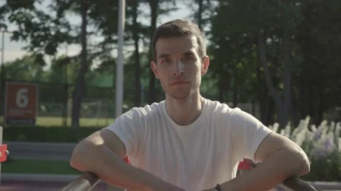 Fit guy standing and resting after workout leaning on a bar Stock Footage 146305626