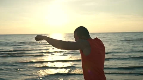Fit man boxing at sunset at the beach Stock Footage 68985182