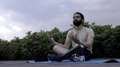 Fit man with disability wearing bionic hi-tech leg prosthesis while meditating  Stock Footage 231805635