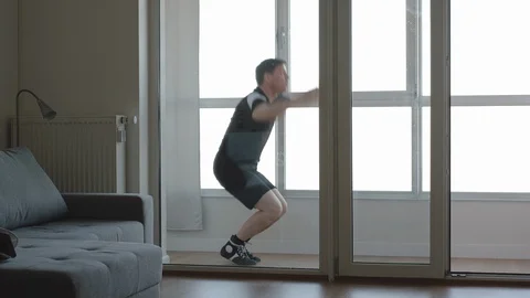 Fit man doing burpee exercises in the balcony. Home wellness training. Vídeo Stock 128285884
