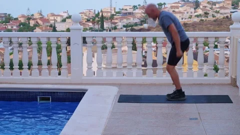 Fit Man Doing Burpees and Fist Push Ups on Outdoor Mat by Swimming Pool Stock-Footage 345385889