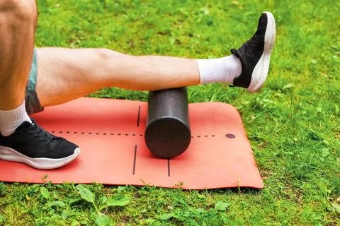 Fit man doing foam rolling for myofascial release and leg muscle recovery, .. Stock Photos