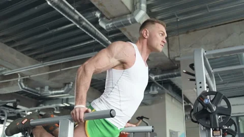 Fit man doing push ups at uneven bars in the gym. Video stock 149983186