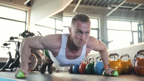 Fit man doing push ups from the floor at gym. Видео 149984064