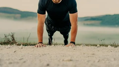 Fit man doing push ups exercise at outdoor gym. Core body workout athlete pla Stock Photos