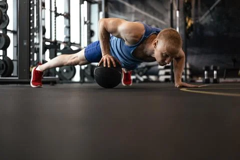 Fit man doing push ups on medicine ball at the gym. Stock Photos