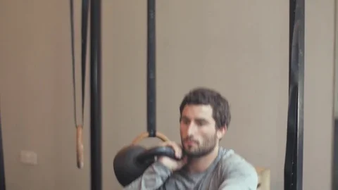 Fit man doing squats and kettle bell presses Stock Footage 77049747