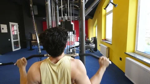 Fit man exercising at the gym on a machine Video stock 75974635