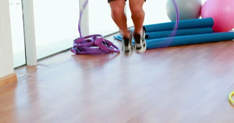 Fit man jumping through a hula hoop Stock Footage 34261594