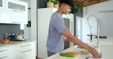 Fit man opening fridge removing boxes slicing carrots packing meal-prep trays Stock Footage 342392786
