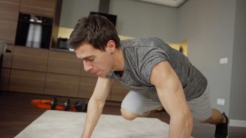 Fit man performing running plank at home Stock Footage 128763898