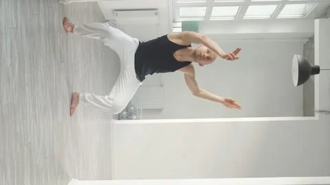 Fit man performs elements of modern dance from a white studio Stock Footage 159855173