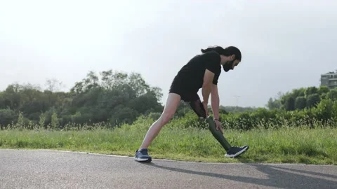 Fit man with physical disability doing stretching warm-up after exercise outdoor Stock Footage 201429970