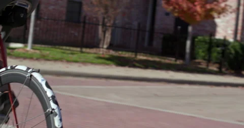 Fit man rides a bicycle through a neighborhood Stock Footage 186833697
