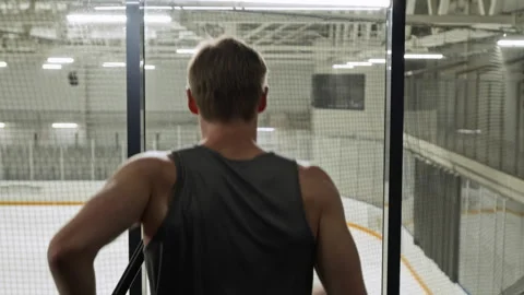 Fit Man Running on Treadmill Overlooking Indoor Ice Hockey Rink Stock Footage 339884461