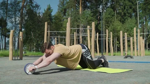 Fit man using an ab wheel for exercises Stock-Footage 250126573