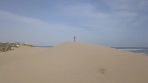 Fit man walking on dunes Vidéo 104375871