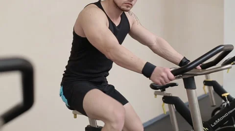 Fit man working out on exercise bike at the gym Stock Footage 62561535