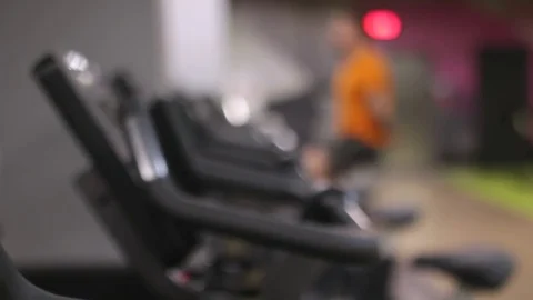 Fit man working out on exercise bike at the gym with bokeh Stock Footage 83129198