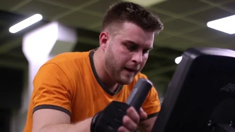 Fit man working out on exercise bike at the gym Stock Footage 83129201