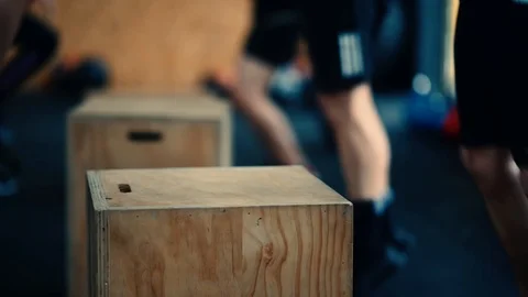 Fit men doing box jumps in gym in slow motion. Stock Footage 93421104