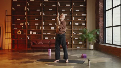 Fit middle-aged man practicing eagle arms during yoga training at home, hobby Stock Footage 340902054
