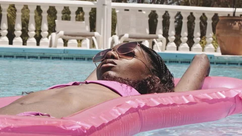 Fit Model on a Vacation Relaxing by the Pool on an Inflatable Stock Footage 138181458