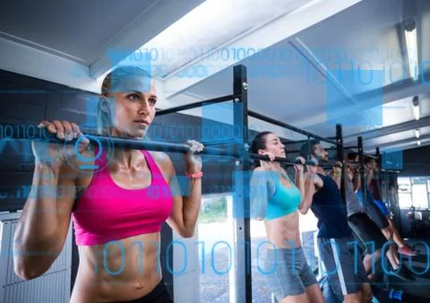 Fit people performing pull up exercise in gym Stock Photos