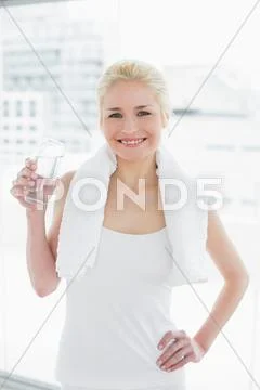 Fit smiling woman with a glass of water at gym Stock Photos