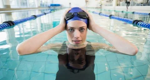 Fit swimmer in the pool smiling at camera Stock Photos