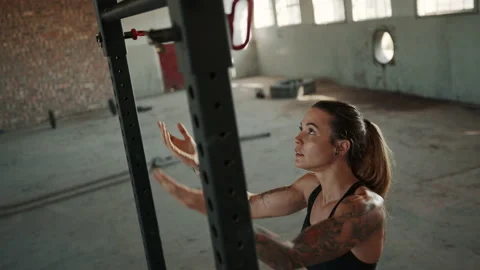 Fit woman doing pull ups exercise at cross training workout space Stock Footage 150863261