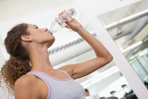 Fit woman drinking from water bottle Stock Photos