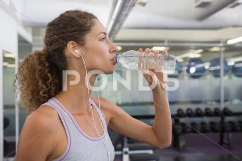 Fit woman drinking from water bottle Stock Photos