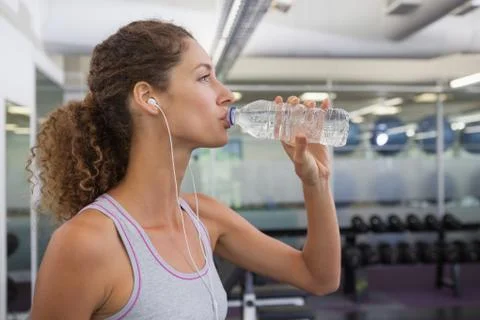 Fit woman drinking from water bottle Stock Photos
