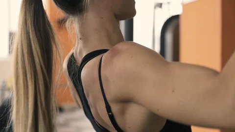 Fit woman exercising with a lat pulldown machine 動画素材 128585223