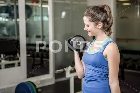 Fit woman lifting dumbbell Stock Photos