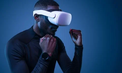 Fit young black guy practicing boxing in VR glasses Stock-Fotos