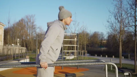 Fit young man doing dips on parallel bars Stock Footage 129556465