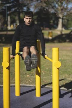 Fit young man doing push ups on horizontal bar outdoors 스톡 사진