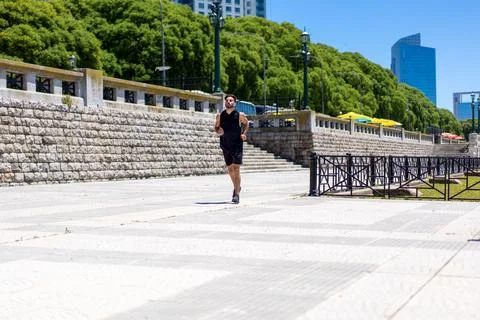 Fit young man elevates his fitness routine with a steady run through lush p.. Stock Photos
