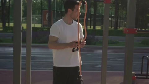 Fit young man preparing for exercising with gym equipment outdoor Stock Footage 146306779