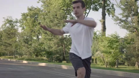 Fit young man preparing for workout doing stretching exercise outdoor Stock Footage 146305335
